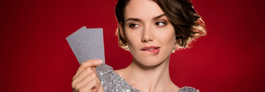 A young woman playing poker biting her lip.  Is she bluffing?