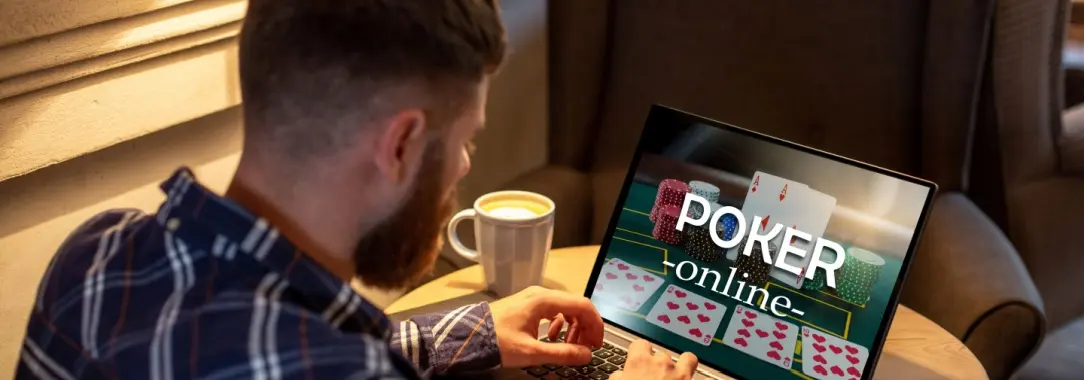 a young man playing poker at home on his laptop