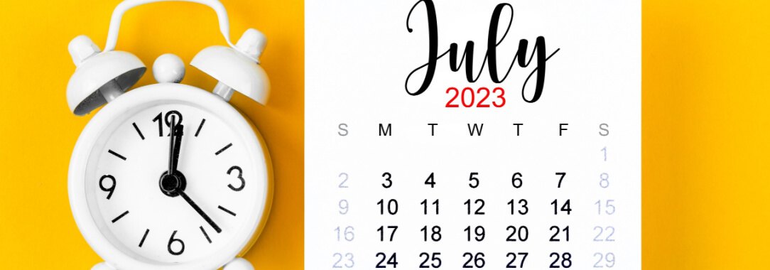 A calendar of the month of July 2023 next to a white alarm clock on a yellow background