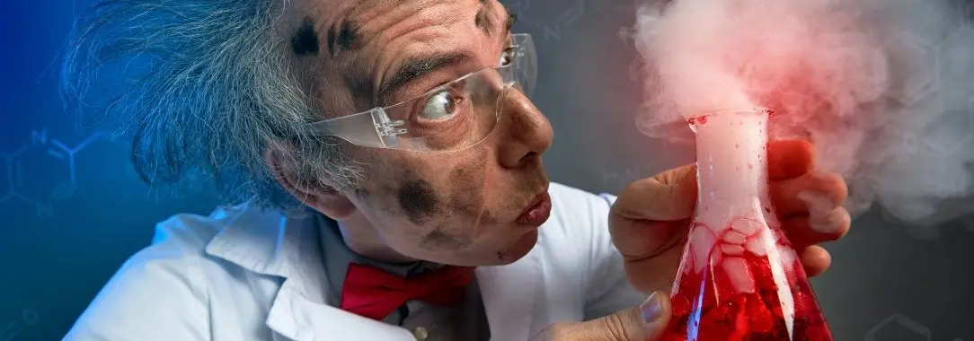 A photo of a surprised scientist with wild hair, red bow tie, and goggles holding a bubbling red flask against dark chemical bac