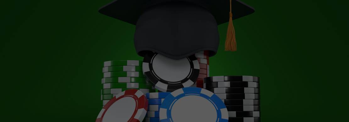 red, blue, and black poker chips covered by a graduation cap with a gold tassel