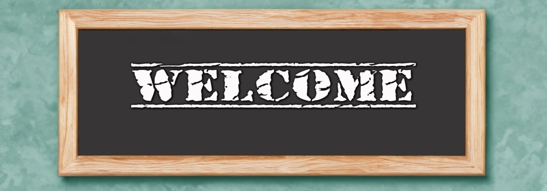 A photo of a framed sign with the word welcome in white on a black background