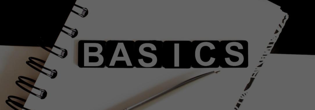 A photo of a wire-bound notepad with the word ‘Basics’ in white on black text underscored by a silver pen 